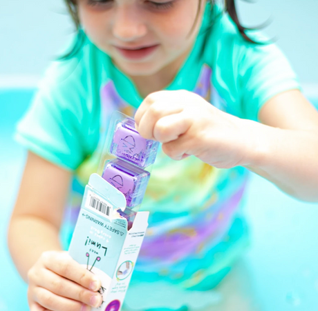 Child playing with Glo Pals Purple light-up cubes from the pack, showing bright purple glowing toys.
