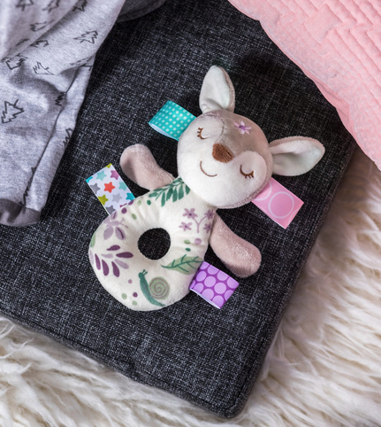 Taggies Flora Fawn Rattle with soft plush, colorful ribbons, sleepy embroidered face, and fern leaf design for babies.