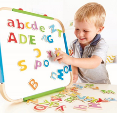 Child playing with colorful ABC Magnets on a whiteboard, matching upper and lower case letters for learning.