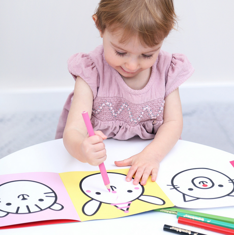 Young child coloring animal illustrations with crayons using the Loong Animals Coloring Book accordion set.