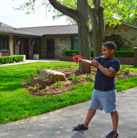 Young boy playing outdoors with the Koosh Flingshot, aiming and ready to fling the special Koosh ball.