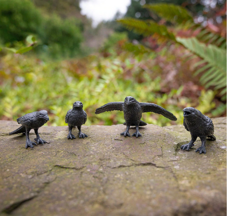 Murder of Crows set showing four detailed hard vinyl crow figures posed naturally on a stone surface outdoors.