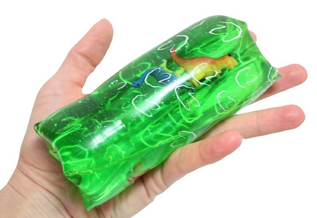 Water Wiggler Dino in green, a squishy water-filled fidget toy with dinosaur inside, held in a hand for playtime fun.
