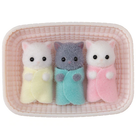 Persian Cat Triplets showing three tiny fluffy kittens wrapped in pastel blankets lying in a pink cradle.
