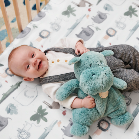 Oh So Snuggly Hippo plush in pastel blue, soft and floppy, held by a happy baby for tactile comfort and play.
