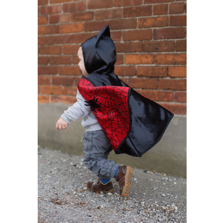 Toddler wearing Baby Spider Bat Reversible Cape Size 2-3 with black bat hood and red spider web cape.