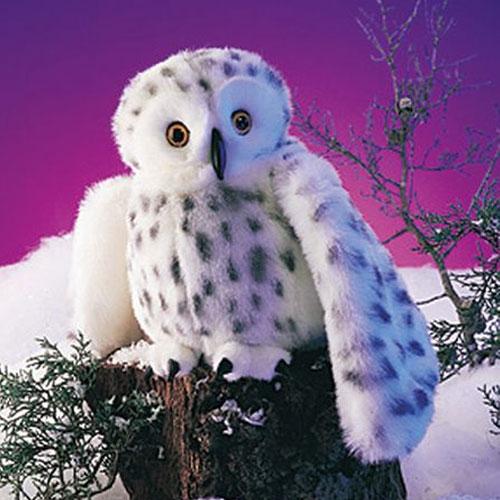 Snowy Owl Puppet with soft feathers, spotted wings, and lifelike eyes perched on a tree stump against a snowy background.