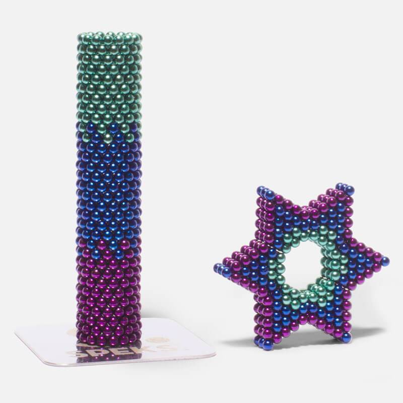 Speks. Gradient. Unwind. showing colorful magnetic balls shaped into a tall column and a star-shaped ring.