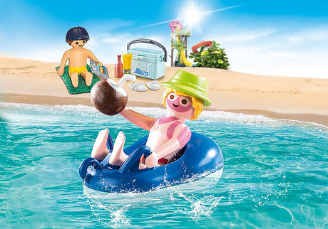 Famly Fun | Sunburnt Swimmer with sunburned figure floating in swim tire holding coconut by the beach.