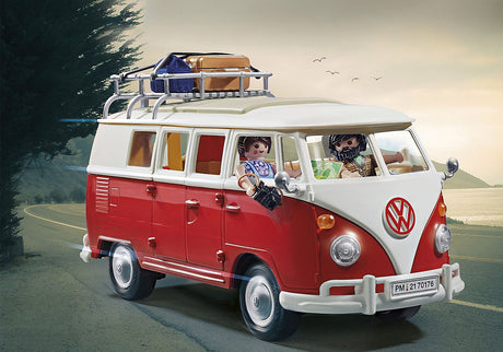 Playmobil Volkswagen T1 Camp Bus with red and white exterior, roof rack, and two figures on a scenic road trip.
