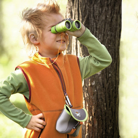 Child exploring outdoors using Terra Kids | Binoculars & Bag with bright green binoculars and carrying case.