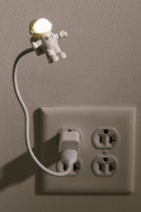 USB Astronaut Light plugged into outlet with illuminated spaceman head on flexible adjustable neck.