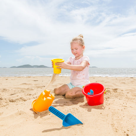 A child playing with colorful sand toys on the beach using the 5-in-1 Beach Set for hours of fun.