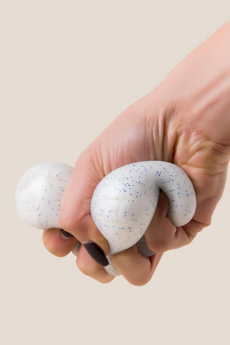 Hand squeezing the NeeDoh Snow Ball, a crunchy stress ball that feels like crunching through fresh snow.