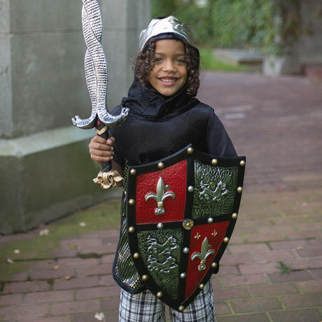 Child dressed as a knight holding the Knight Shield with red and gold lion and fleur de leaf design outdoors.