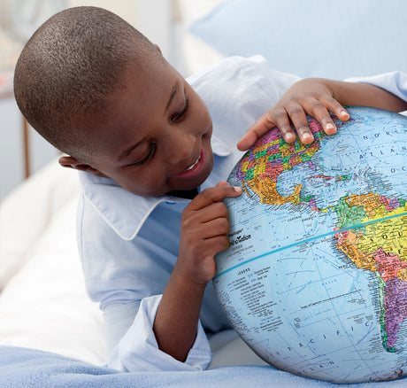 Child exploring the world with the Explorer Globe, a colorful 12" desktop globe with raised relief and detailed maps.