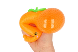 Hand squeezing bright orange Fruit CrushOs Orange toy, perfect for fidgeting and squishing fun.