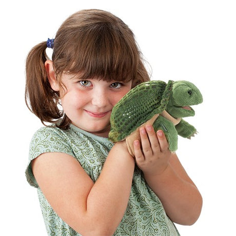 Girl holding a Turtle Little Hand Puppet with movable mouth and flippers, perfect for children aged 3 and up.